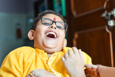 Close-up of boy laughing while sitting at home
