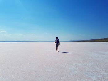 Rear view of man walking on shore