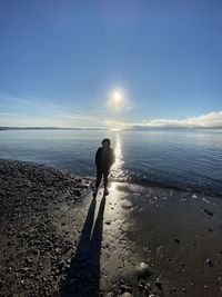 Silhouette woman on beach against sky