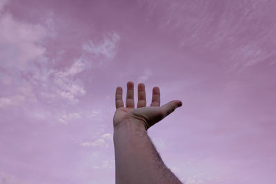 Low angle view of hand against sky