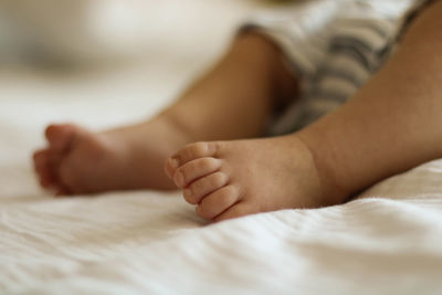 Low section of boy lying on bed