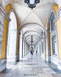 Rear view of people walking in corridor of building