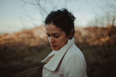 Side view of woman standing on land against sky