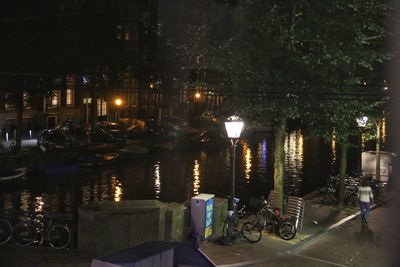 Bicycle parked in canal at night