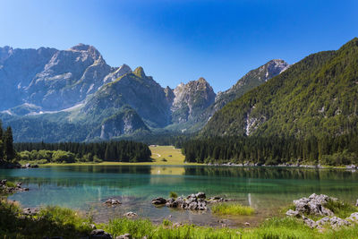 Scenic view of lake and mountains against clear sky