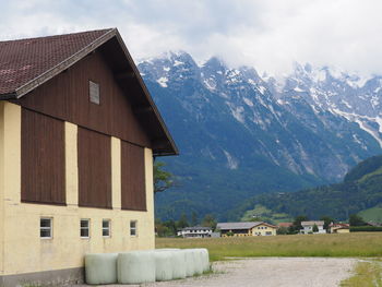 House by mountain against sky