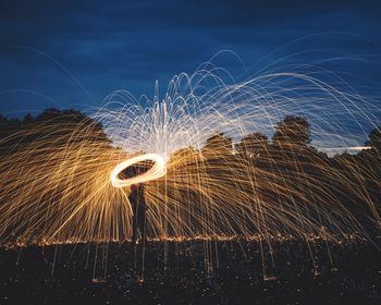 Low angle view of illuminated fireworks against sky at night