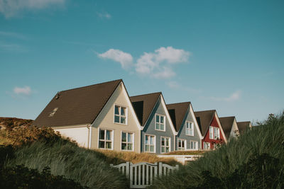 Houses amidst trees and buildings against sky