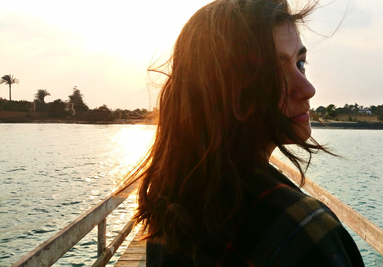 CLOSE-UP OF YOUNG WOMAN AT RIVERBANK