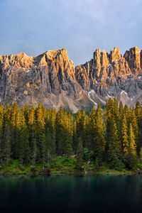 Scenic view of lake by mountains against sky