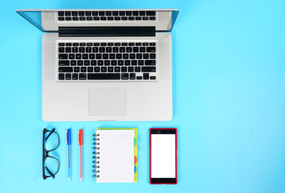 Directly above shot of laptop on table against blue background