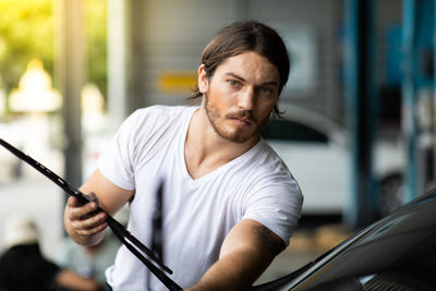 Portrait of young man holding camera