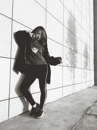 Full length portrait of young woman standing on floor