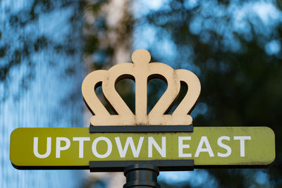 Close-up of road sign against sky