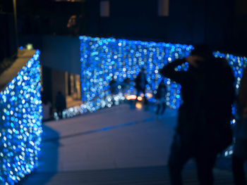 Man with illuminated christmas lights at night