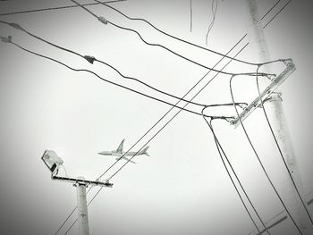 Low angle view of power lines against clear sky