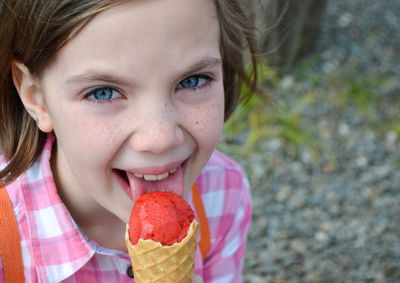 Holding fresh waffle cone with raspberry ice cream