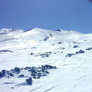 Scenic view of snowcapped mountains against clear blue sky