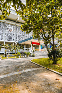 Footpath amidst trees and buildings in city