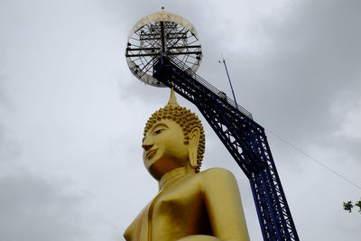 Low angle view of statue against temple against sky