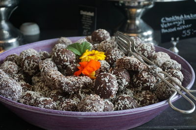 Close-up of chocolate coconut cakes in container with serving tongs on table
