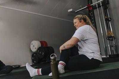 Smiling woman stretching in gym during fitness class