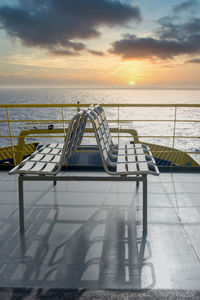 Empty chairs of an outdoor upper deck in a transport ferry at sunset near the coast of the island 