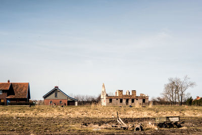 Houses on field against sky