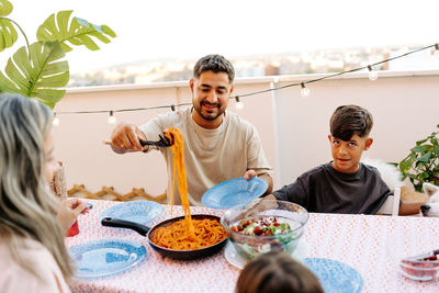 Smiling family celebration. kids and father are happy that food arrived. celebrating little sister