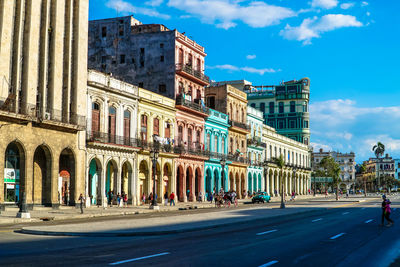 Street by buildings against sky in city