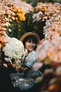 Portrait of baby girl standing on flowering plant