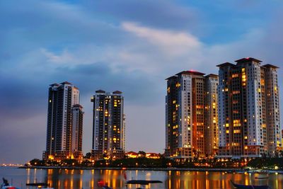 Illuminated cityscape against sky at night