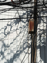 Low angle view of electric lamp hanging on wall