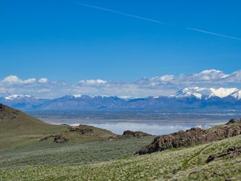 Scenic view of landscape and mountains against blue sky