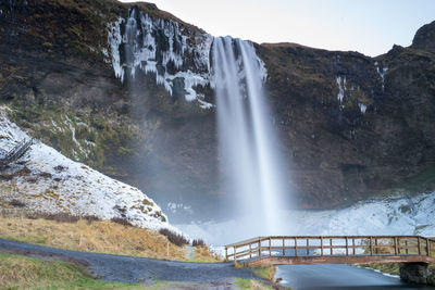 Scenic view of waterfall against sky