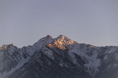 Scenic view of snowcapped mountains against clear sky