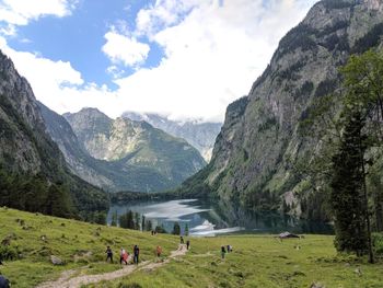 Scenic view of mountains with people on land against sky