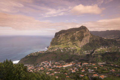 Scenic view of sea and mountains against sky