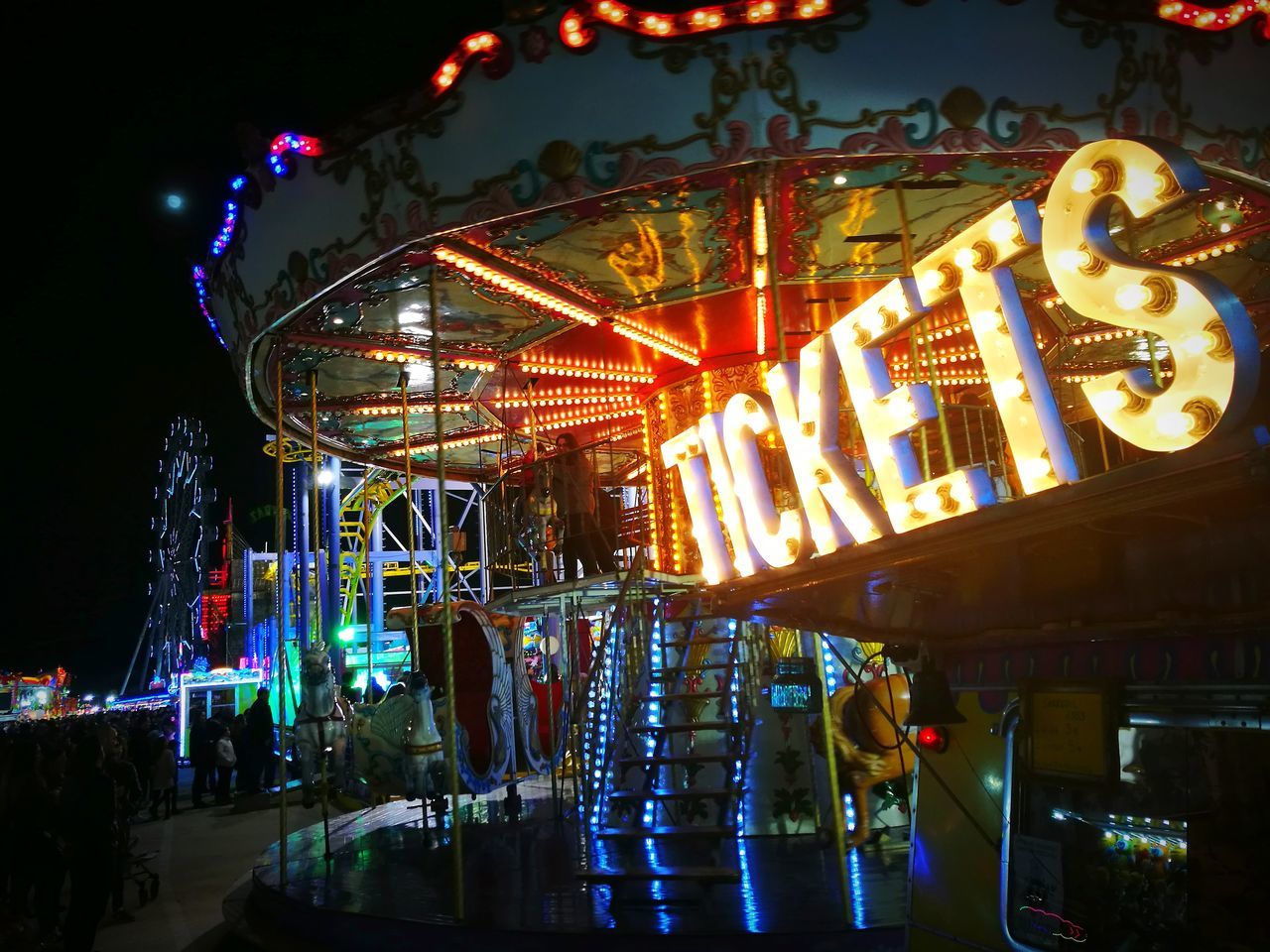 amusement park, arts culture and entertainment, illuminated, night, amusement park ride, carousel, leisure activity, enjoyment, merry-go-round, low angle view, multi colored, outdoors, no people, nightlife, sky