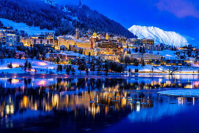View of beautiful night lights of st. moritz in switzerland at night in winter, reflection from lake