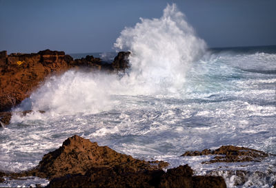 Waves splashing on rocks against sea