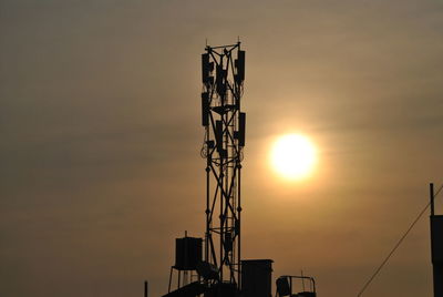 Low angle view of silhouette cranes against sky during sunset