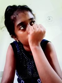 Portrait of cute girl looking away against wall