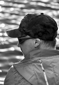 Rear view of man wearing cap against lake