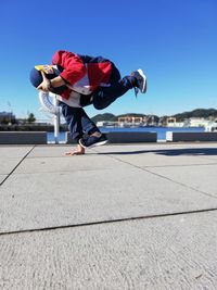 Full length of boy on umbrella against sky