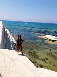 Woman standing on rock at beach