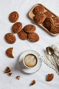 Delicious coffee with a drawing made with cream and homemade cookies