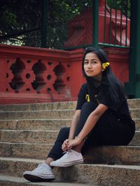 Portrait of young woman sitting on staircase