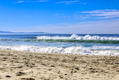 Scenic view of beach against blue sky