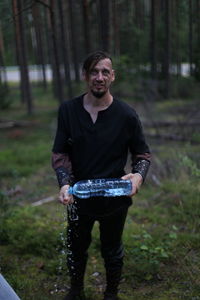 Portrait of young woman standing in forest